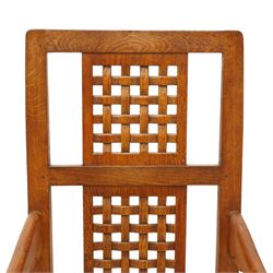 Mouseman - 1940's dark-honey oak rocking chair, high back with pierced double-lattice panel, over a beige-leather upholstered seat, shaped arm terminals above turned octagonal front-supports united by rocker base, with carved mouse signature, by the workshop of Robert Thompson of Kilburn