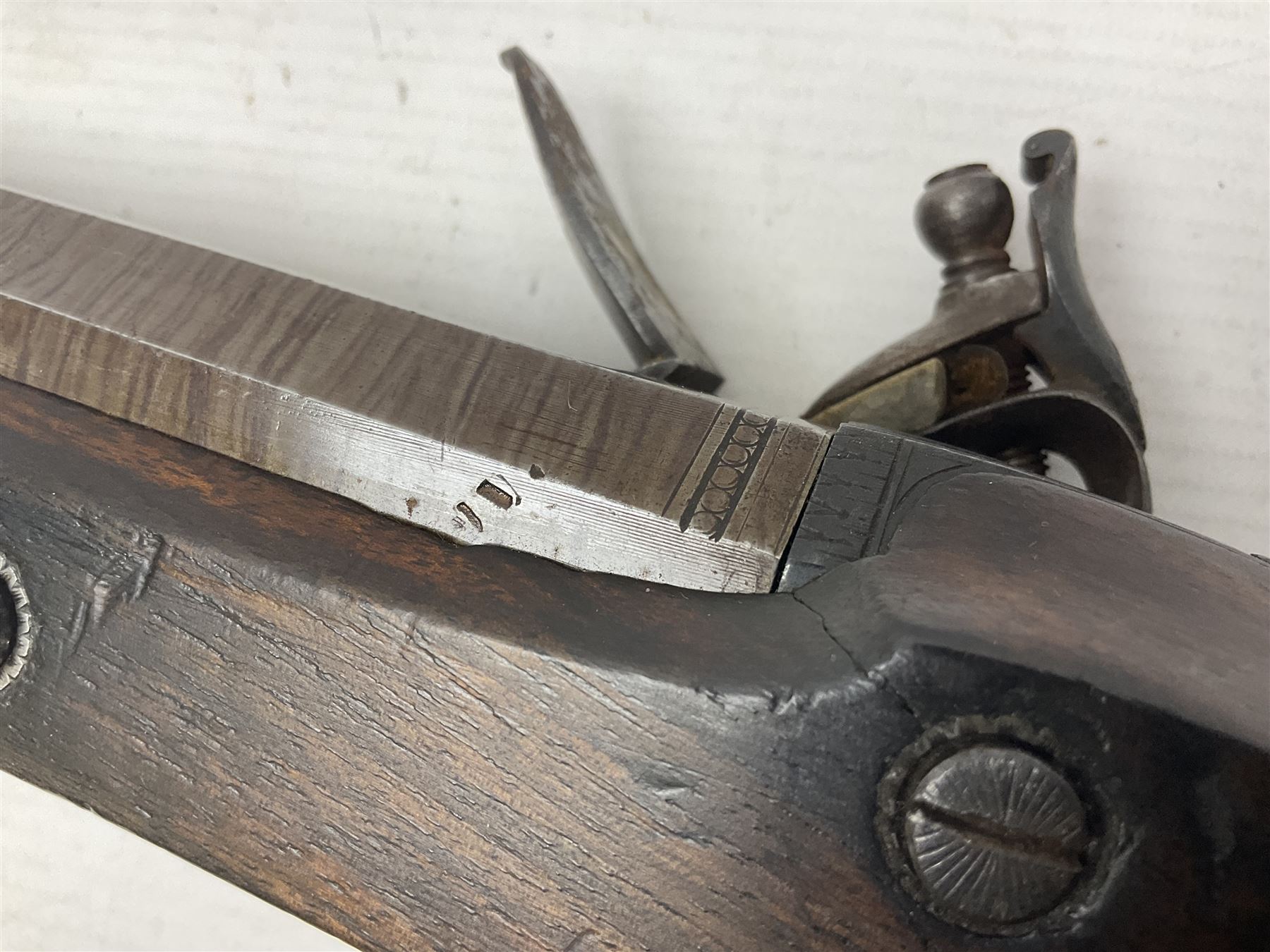 Early 19th century 16-bore flintlock single barrel travelling pistol, the 21.5cm stub twist octagonal barrel with two barrel pins and ramrod under, engraved lock plate with roller frizzen, engraved trigger guard with pineapple finial, walnut stoock with chequered grip L40cm overall