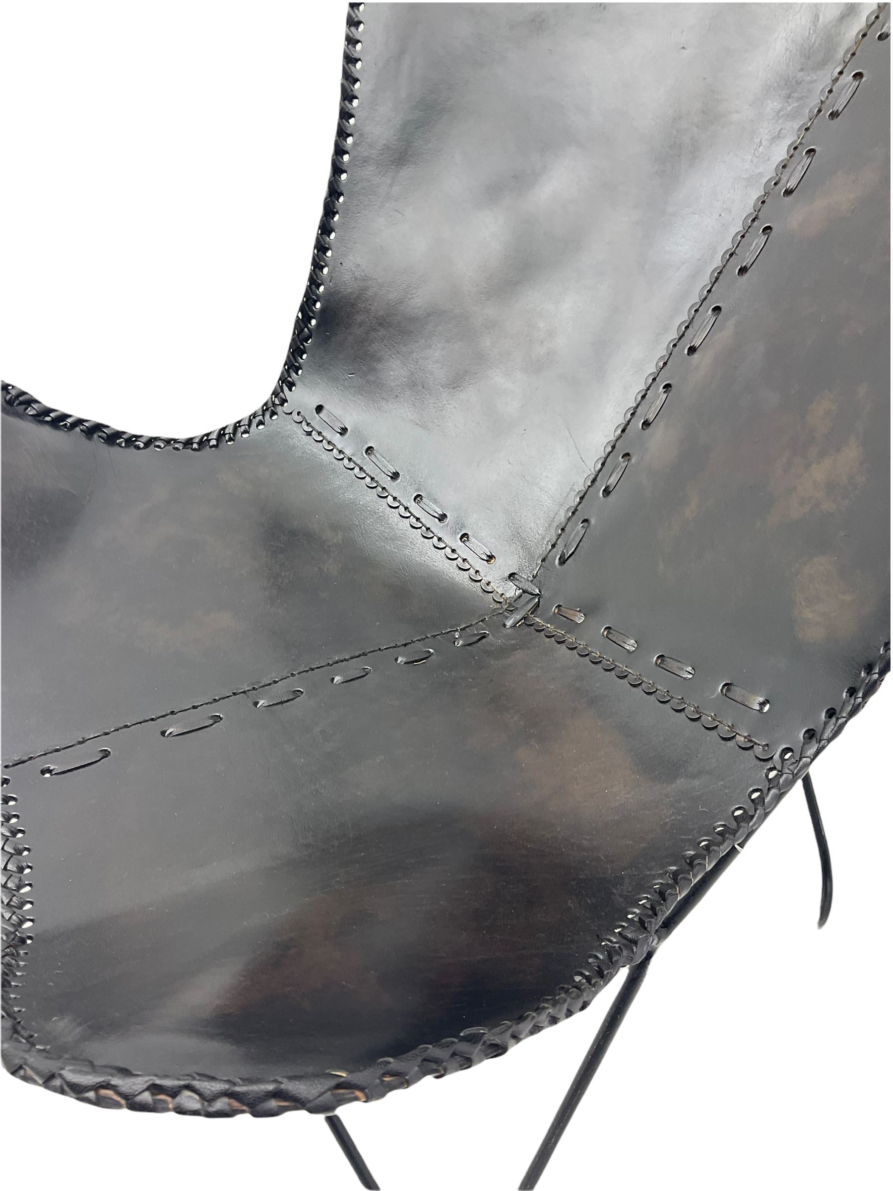 Metal framed butterfly chair upholstered in slung dark tan stitched leather 