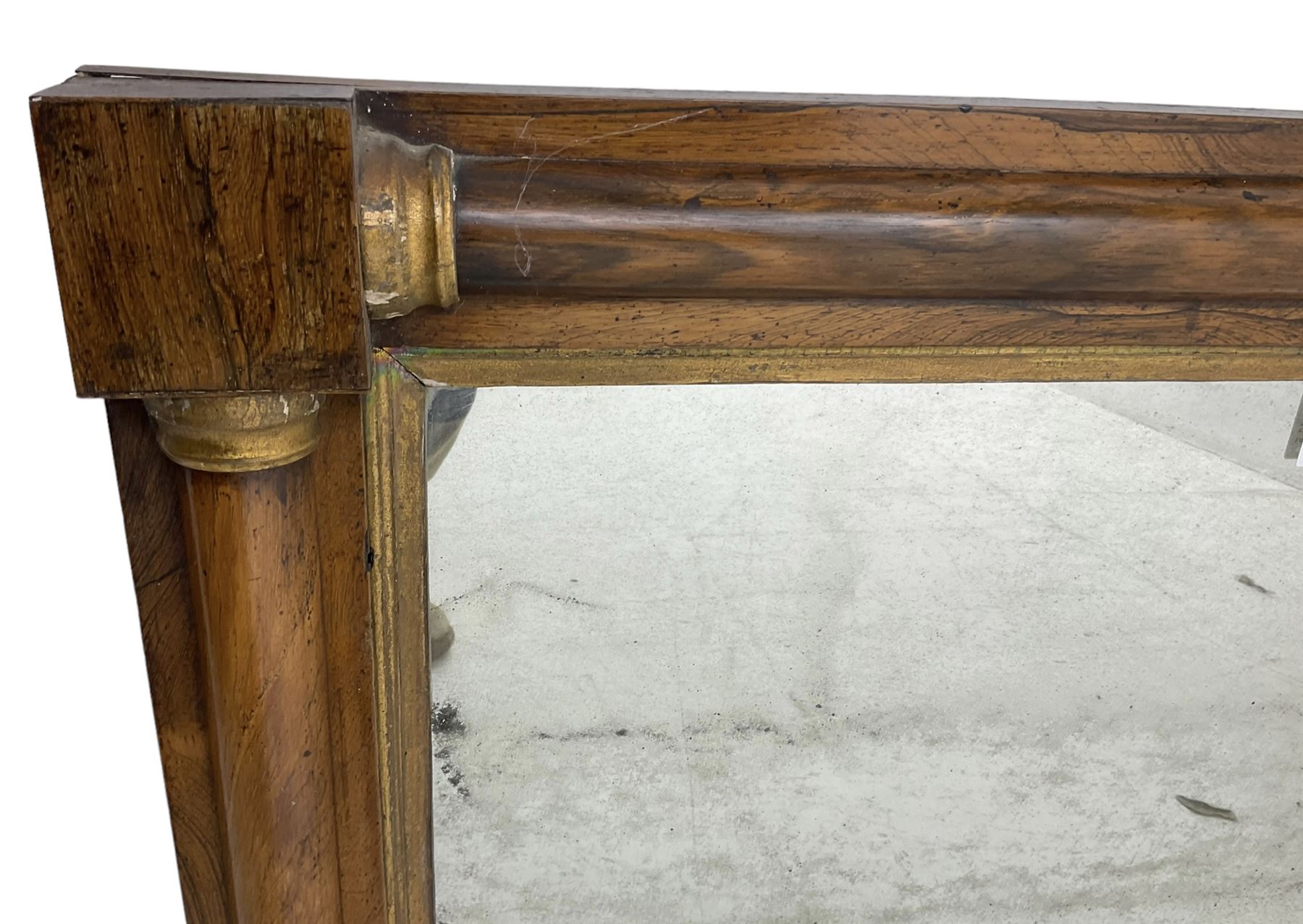 Early 19th century rosewood overmantel mirror, rectangular form with turned half pilasters, moulded gilt slip enclosing plain mirror plate, on turned feet