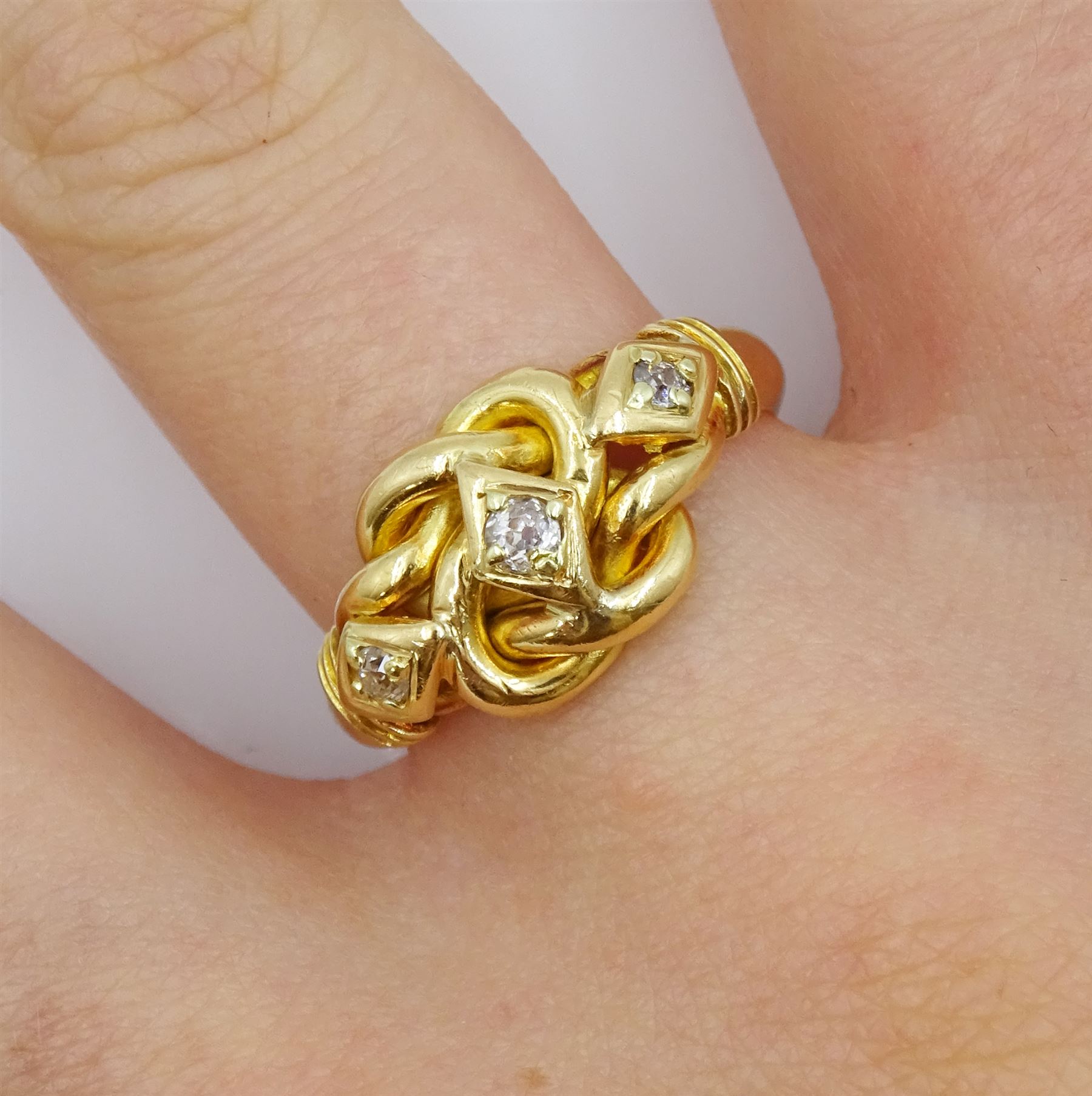 Edwardian 18ct gold three stone old cut diamond love knot ring, maker's mark EK, London 1903