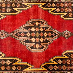 West Persian Mazlaghan hand-knotted rug, madder red field with central stepped lozenge medallion with pendant motifs flanked by angular serrated spandrels filled with small geometric devices, enclosed within multiple borders featuring stylized floral and geometric motifs, with cotton fringe ends 