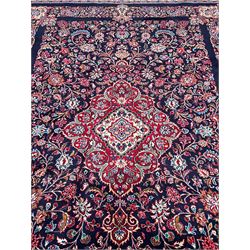Persian Hamadan indigo ground carpet, the field decorated with central rectangle and outer band, overall floral pattern with cusped central medallion and surrounding leafy branches with palmettes, the border with scrolling branches decorated with further palmettes, within floral pattern guard stripes