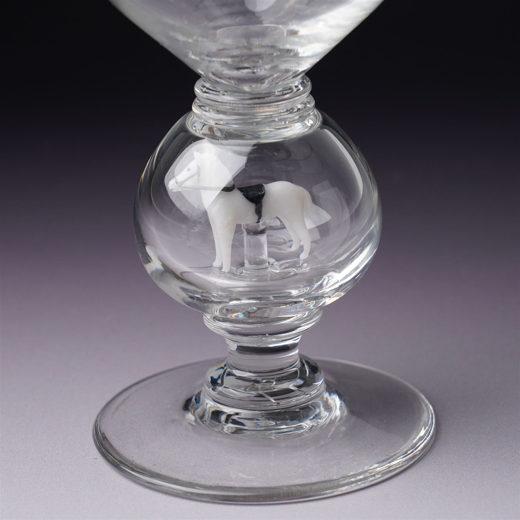 Set of six 1930s glass goblets by William Swingewood for Stevens & Williams, each goblet with lampwork glass stem, the large hollow blown knop containing dog, pair of hounds, horse, raven and two with flowers, H18cm (6)
