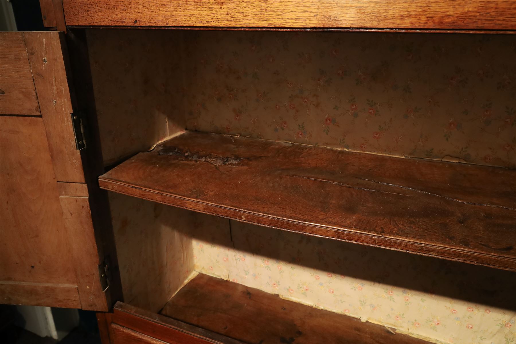 18th century oak larder cupboard, projecting moulded cornice over two panelled doors with shaped arched fielded panels, three short dummy drawers above base fitted with two short and one long drawer, turned handles, on bracket feet