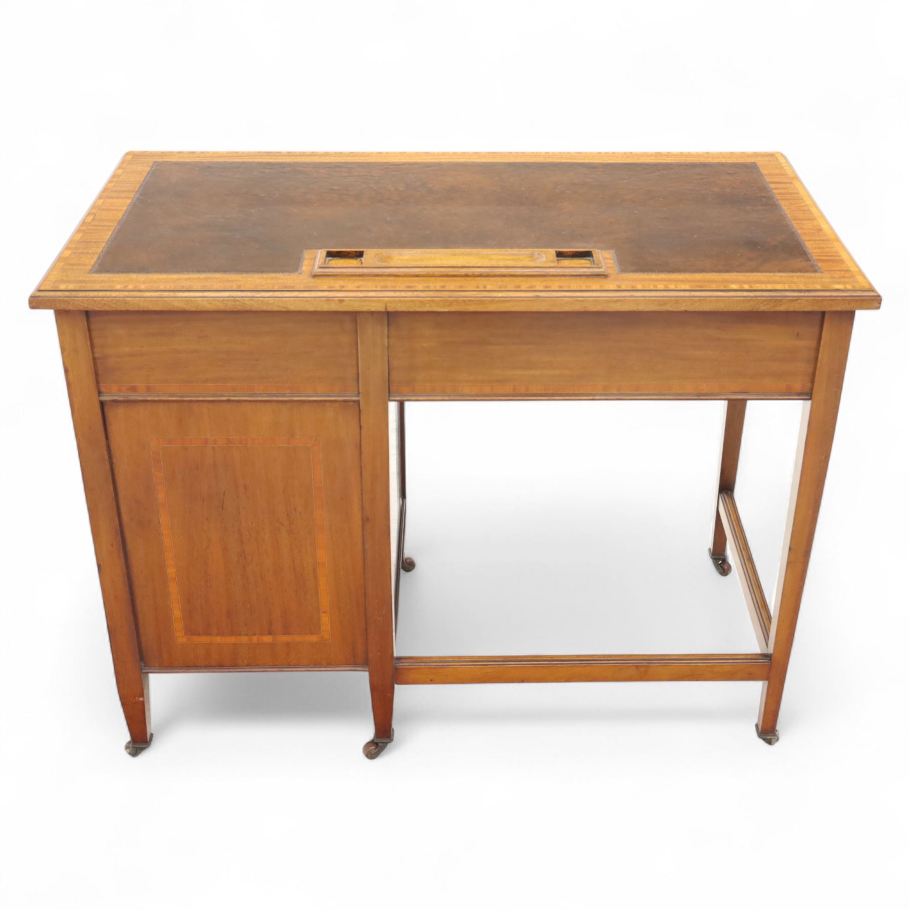 Early 20th century Edwardian mahogany single pedestal writing desk, the crossbanded rectangular top inset with brown leather, fitted with five drawers with brass swan neck handles, upon square tapering supports terminating in brass castors