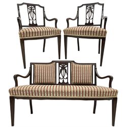 Edwardian mahogany framed three-piece salon suite - two-seat sofa, stepped cresting rail over acanthus and scroll carved pierced splat, upholstered in striped fabric (W124cm, H87cm, D62cm); and a pair of matching armchairs (W60cm) 