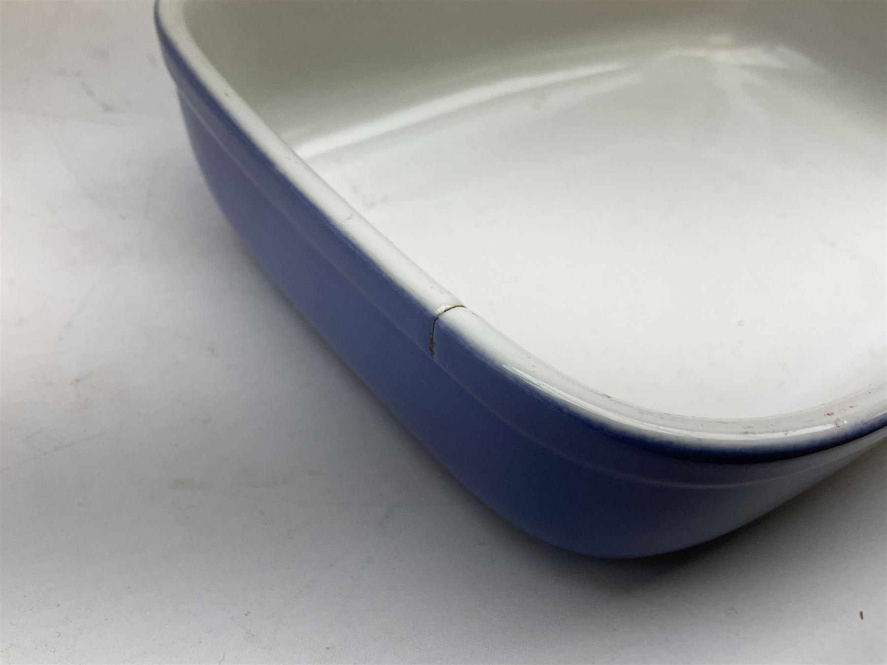 Emile Henry covered casserole dish of oval form in two tone brown and cream, no. 03.06, together with cast iron Nomar twin handled lidded casserole dish of oval form in navy, and other ovenware including Flintware ICTC, largest L35cm