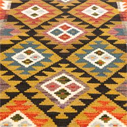 Afghan Maimana flatweave kilim runner, central field features large bold nested diamond motifs and stylized geometric lozenge patterns on olive purple, blue, and green tone ground, border stripe in orange ground, and fringe