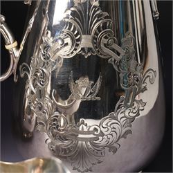 Pair of large silver plated sauce boats with bead edge decoration and C scroll handles engraved with a crest in the form of a winged heart and on shaped supports L20cm Maker probably Hawksworth Eyre & Co and an engraved hot water jug and a matching smaller jug with the same crest and by the same maker