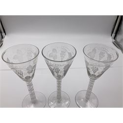 Set of three 18th century style wine glasses, each with funnel bowl etched with fruit vine, upon a double series air twist stem and circular foot, H17cm