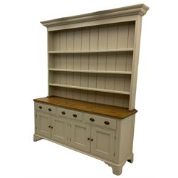 Victorian pine dresser, raised painted three heights plate rack with projecting cornice, waxed top over pained base fitted with three drawers and two double cupboards, bracket feet