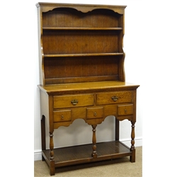  Early 20th century medium oak dresser, projecting cornice above two shelve plate rack, two long and three short drawers, turned supports joined by an undertier, W104cm, H188cm  