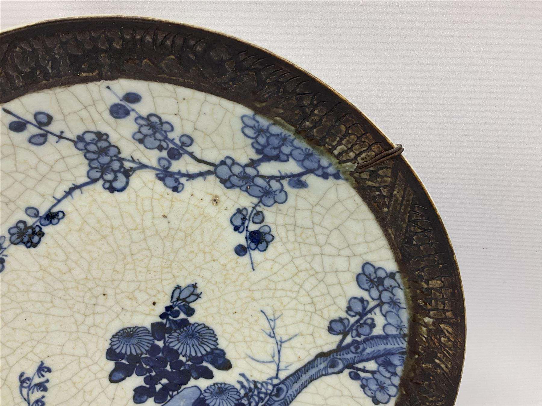 20th century Chinese blue and white crackle glaze charger, decorated with peonies, prunus blossom, and rockwork, within simulated bronze border, with character mark verso, D34cm