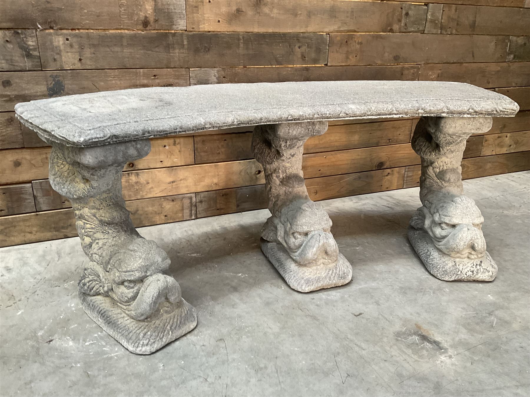 Cast stone four piece curved Dolphin bench, set with three dolphin pillars, curved rectangular slab top with detailed border