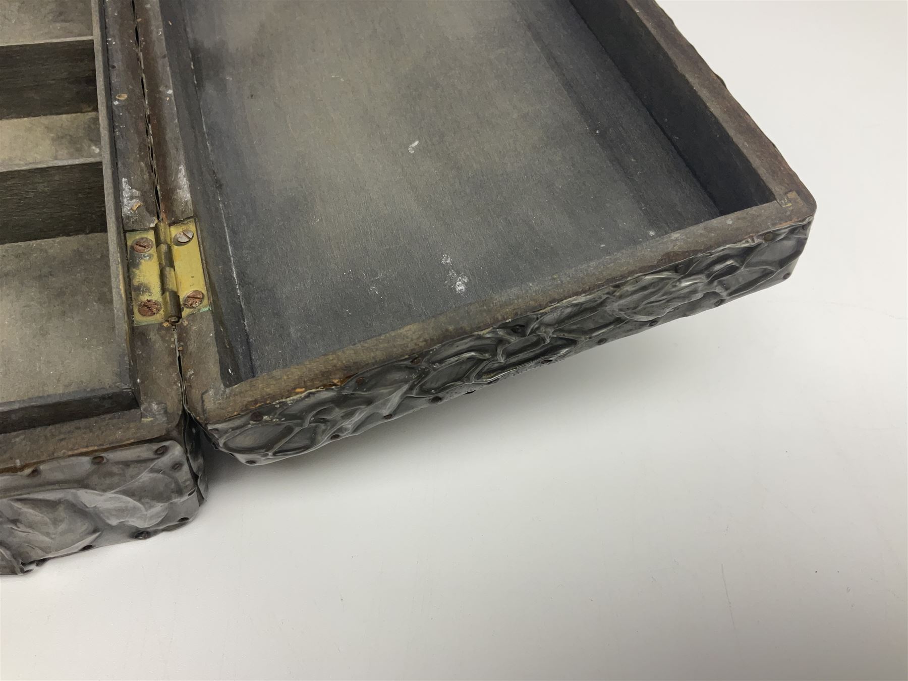 Liberty & Co Tudric pewter cigarette box, of plain rectangular form, with planished decoration to the slightly domed cover, opening to reveal a softwood interior, stamped Made in England 01234 Tudric Solkets beneath, together with another cigarette box, with applied pewter panels repousse decorated throughout with flower heads and leaves, with compartmentalised softwood interior, largest H5.5cm, W23cm