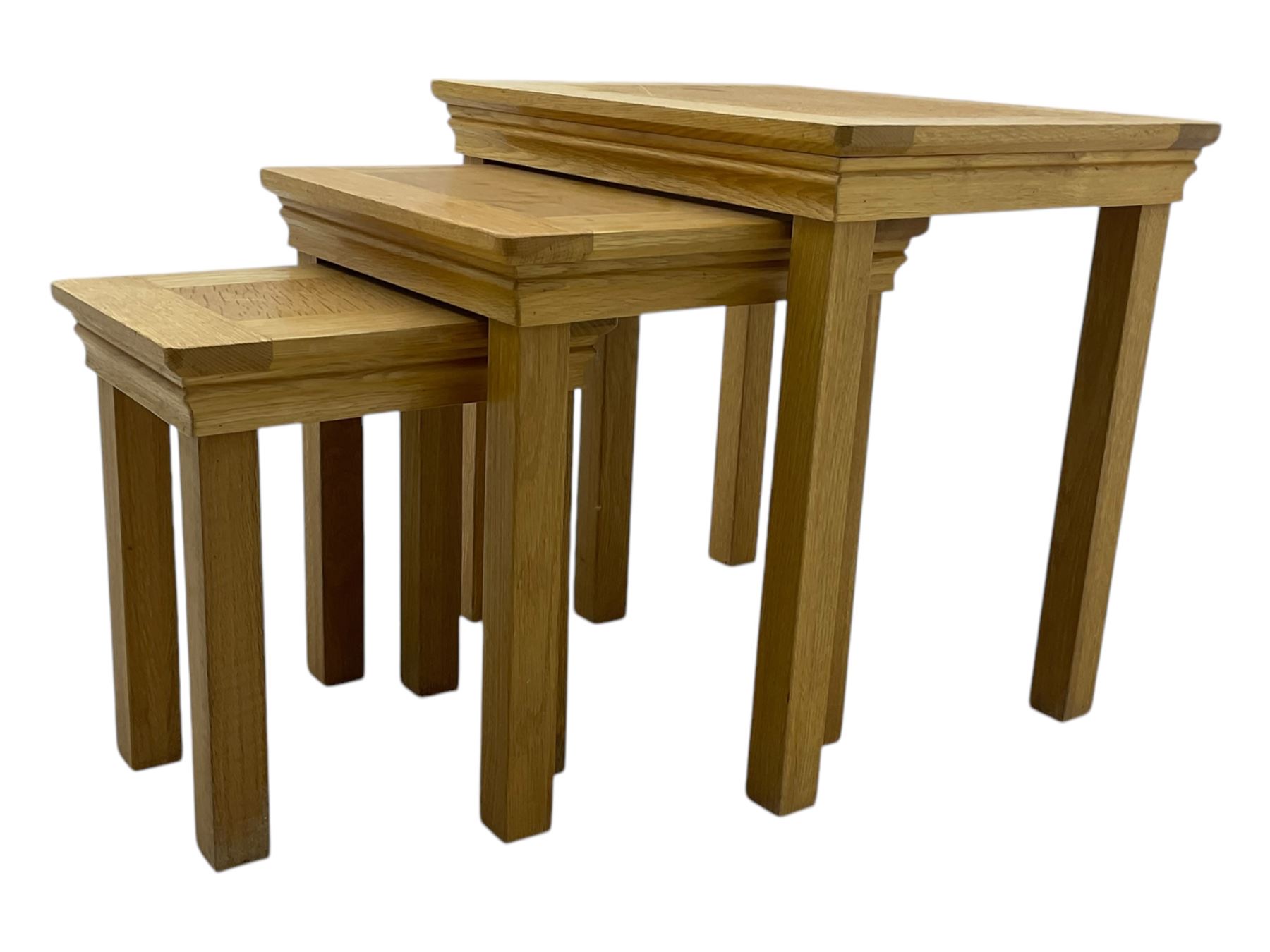 Contemporary light oak nest of three tables, each with rectangular top with moulded edge, raised on square supports