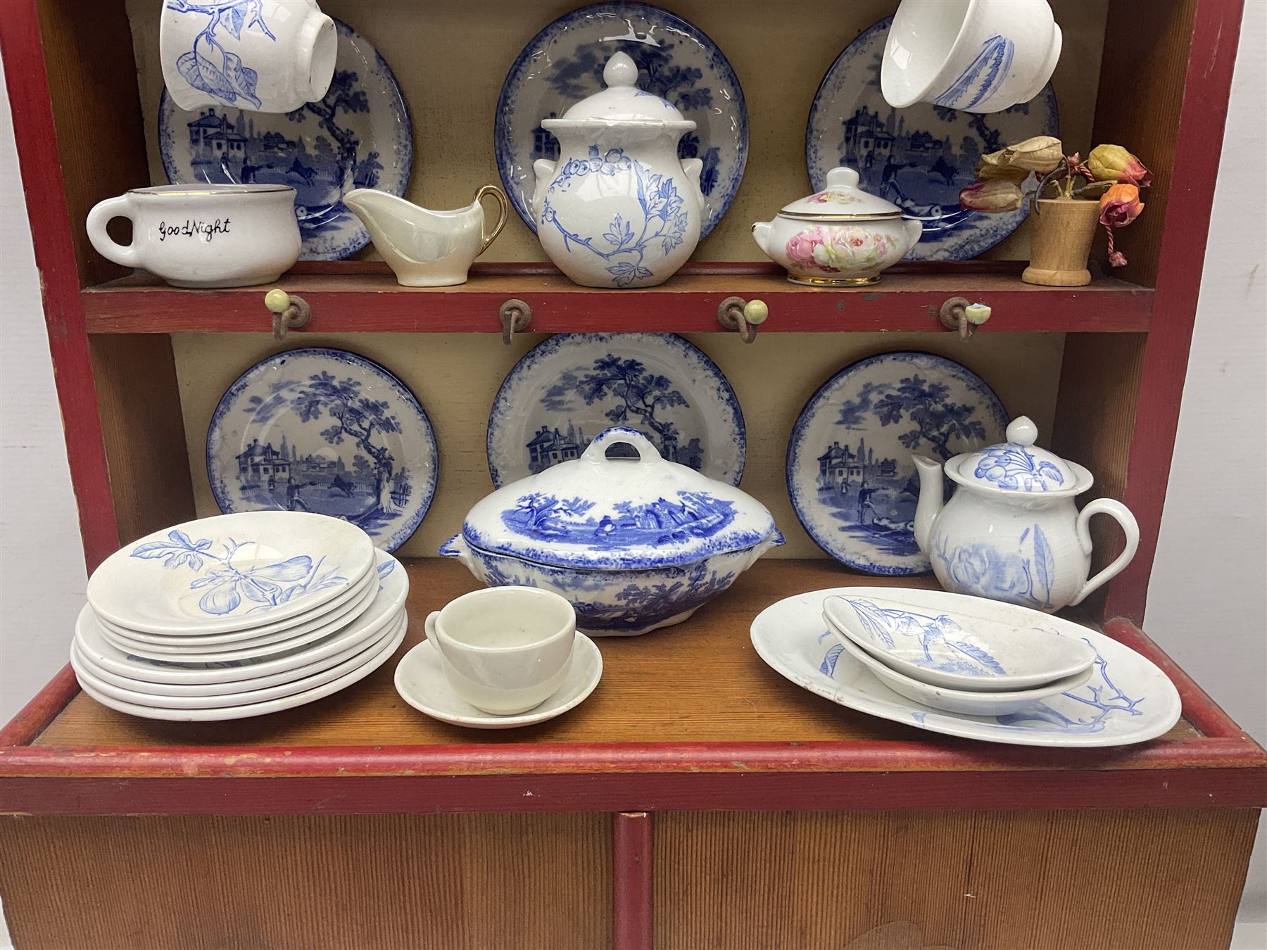 Miniature pitch pine Welsh dresser with open plate rack over two cupboard doors, displayed with Ridgways Humphrey's Clock pattern and other doll's blue/white tea ware, copper kettles and pan etc W41cm H72cm