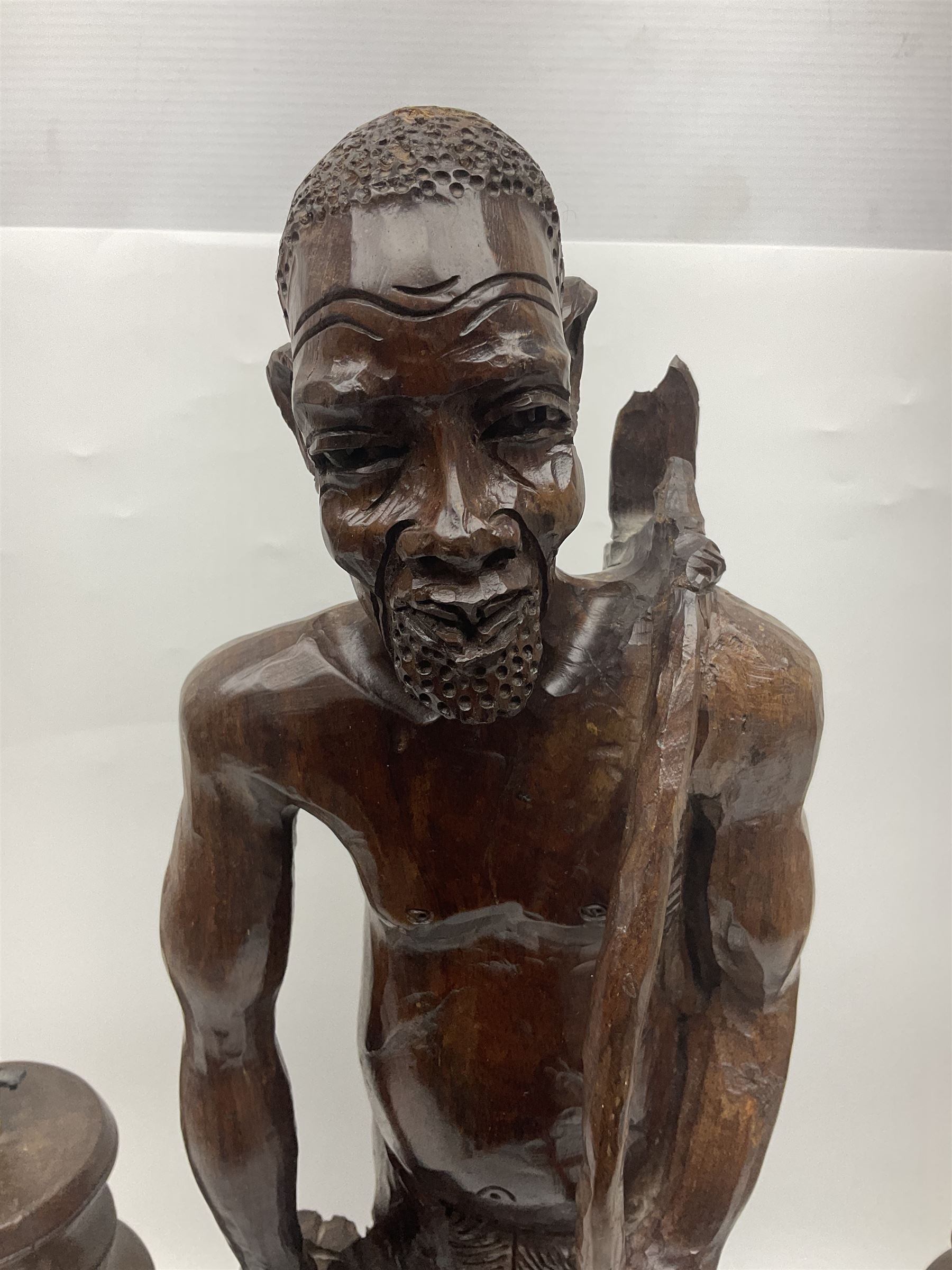 Pair of 20th century carved wood table lamp with African busts and figures, together with a carved wooden figure and soapstone figure, lamps H44cm