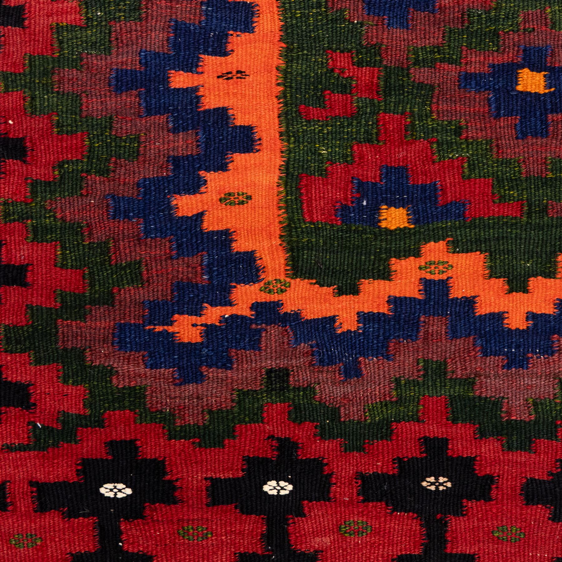 North East Persian Sumak flatweave kilim, woven with an all-over arrangement of stepped diamond motifs, including a diagonal band of contrasting colours in shades of red, indigo, green, pink, and ivory, framed by multiple geometric borders incorporating serrated chevron designs  