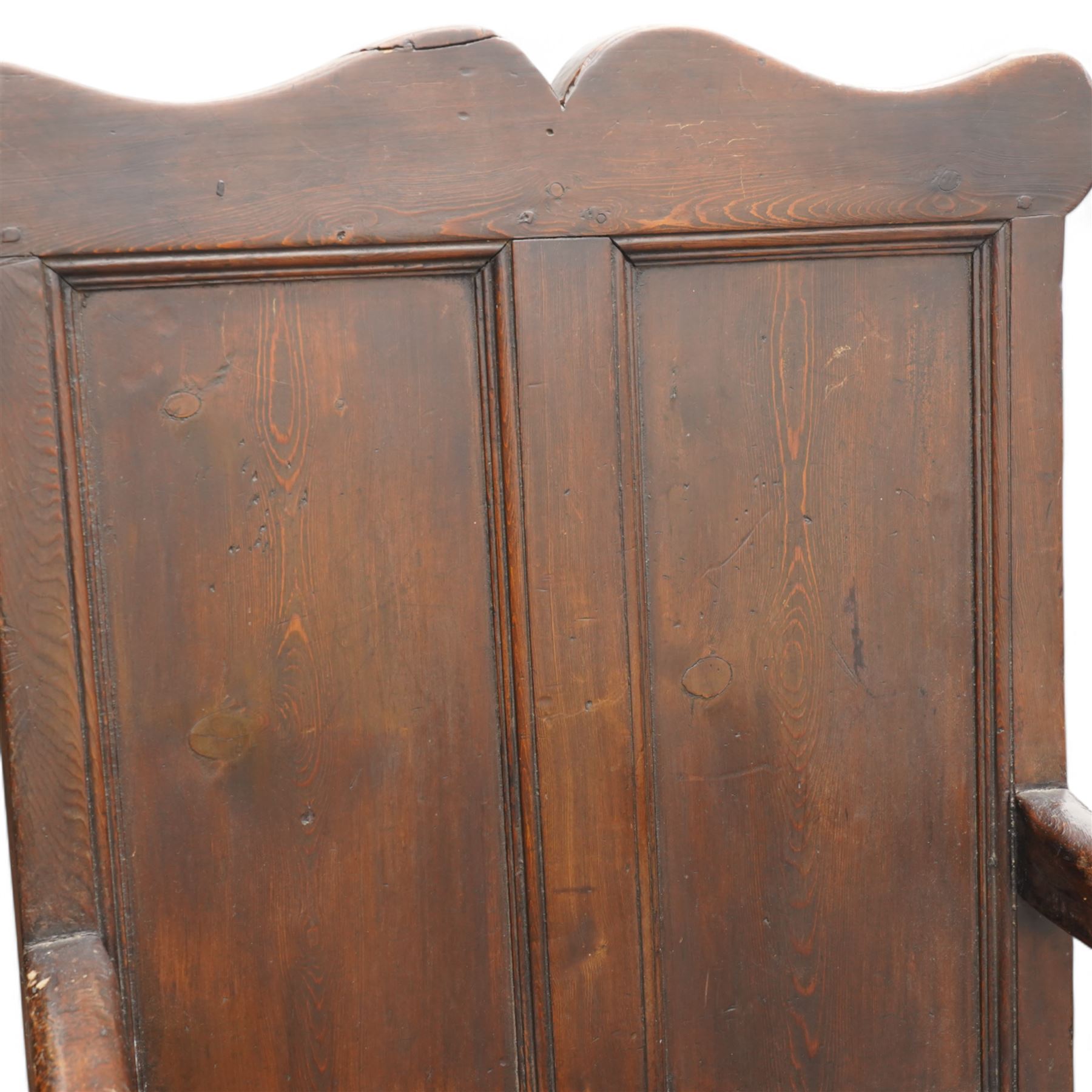 Early 18th century oak open armchair, high back with two recessed panels beneath scrolled cresting rail, curved arms and box seat, raised on square-section supports united by stretchers