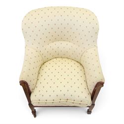 Edwardian inlaid mahogany armchair of modest proportions, spoonback and loose seat cushion on sprung seat upholstered in ivory ground floral fabric, on square tapering supports with ceramic castors