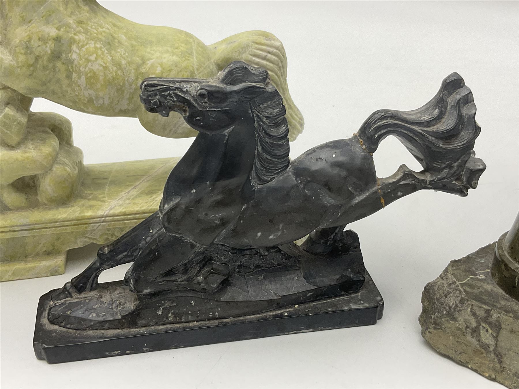 Cornish carved serpentine model of a lighthouse, together with a Chinese soapstone figure of a horse, another carved horse figure and a carved hardstone armadillo