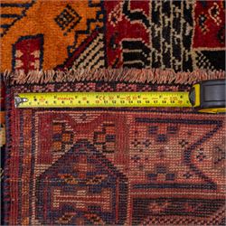 South West Persian Qahqai pictorial hand-knotted rug, madder red field with an all-over pattern of repeating rosettes enclosed with angular leaves and corners with stylized animals figures, central stylized lion in rearing stance and raised forelegs and a human figure shown in profile within a principal border of alternating octagonal and diamond medallions, each enclosing stylized rosettes, flanked by guard stripes incorporating latch hook motifs, with cotton fringe ends  