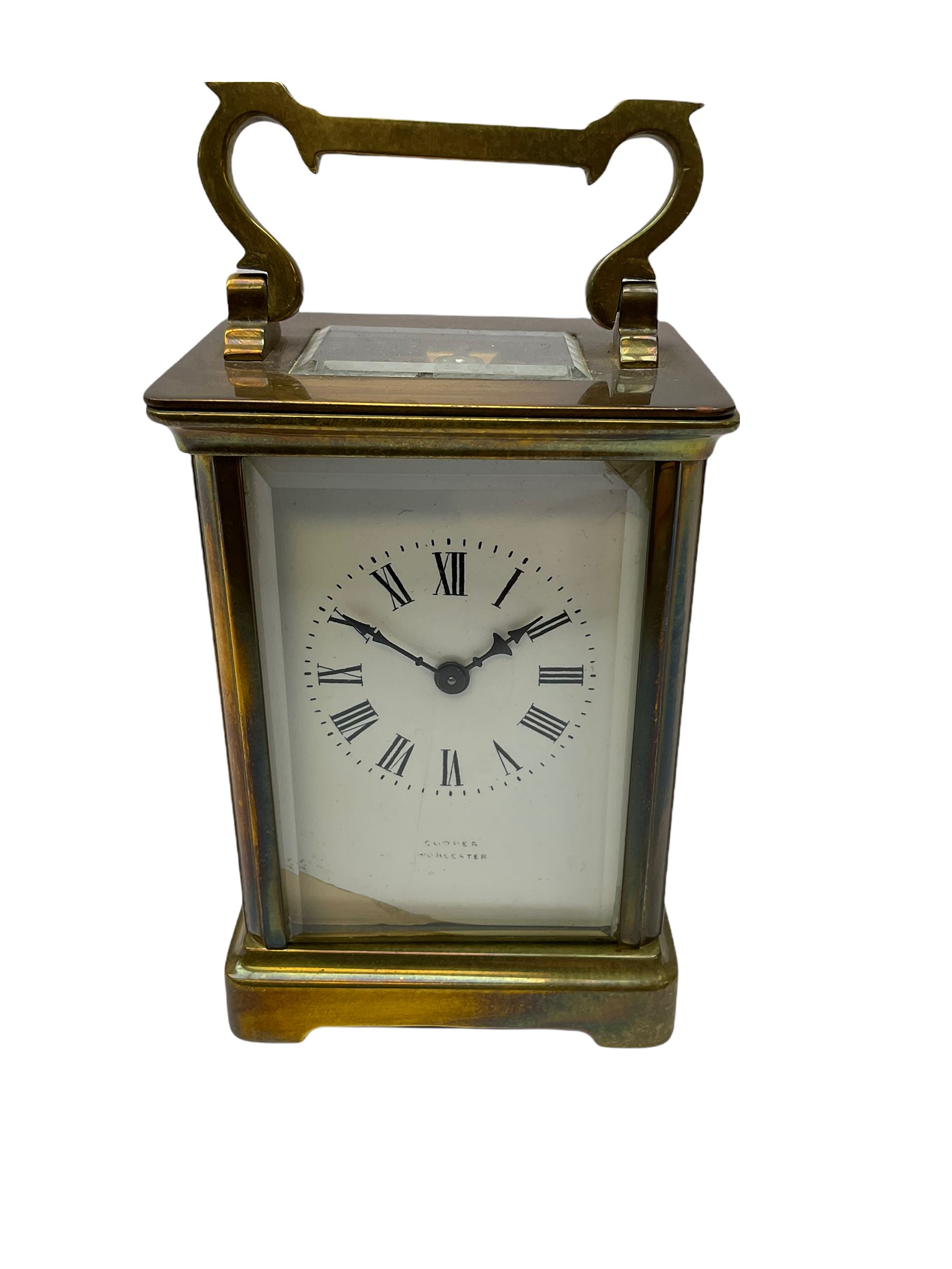 An early 20th century French timepiece carriage clock in a Corniche case with a white enamel dial , Roman numerals, decorative steel hands and minute markers, four bevelled glass panels and a rectangular panel to the top, with a replacement jewelled lever platform escapement with timing screws.