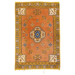 Turkish Anatolian hand-knotted carpet, salmon ground centred by a blue and cream octagonal...