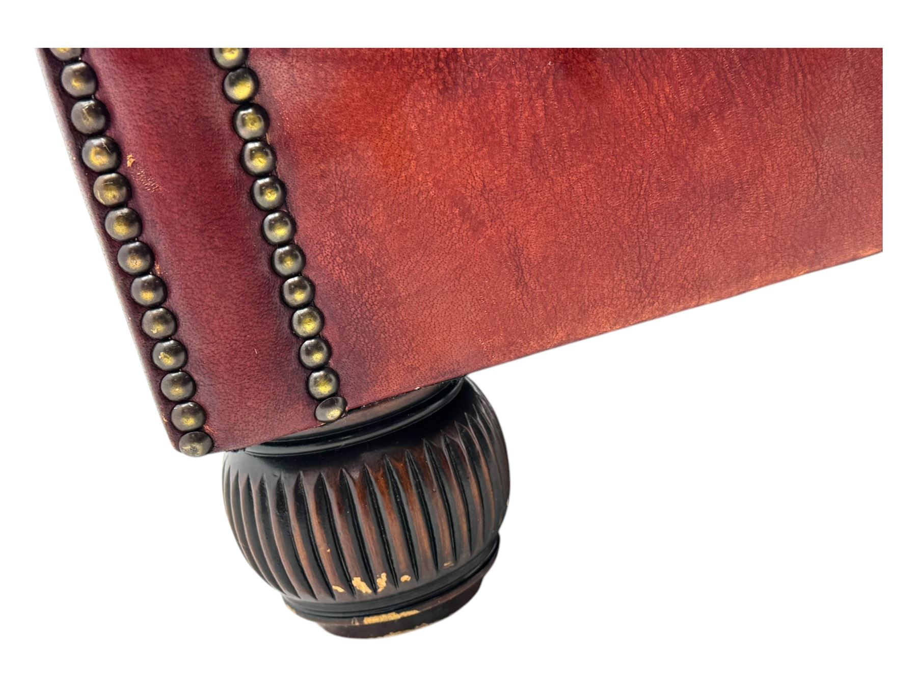 Tetrad - pair of 'Oskar' wingback armchairs, deep-buttoned oxblood leather upholstery with rolled arms and brass stud trim, raised on turned and reed moulded feet