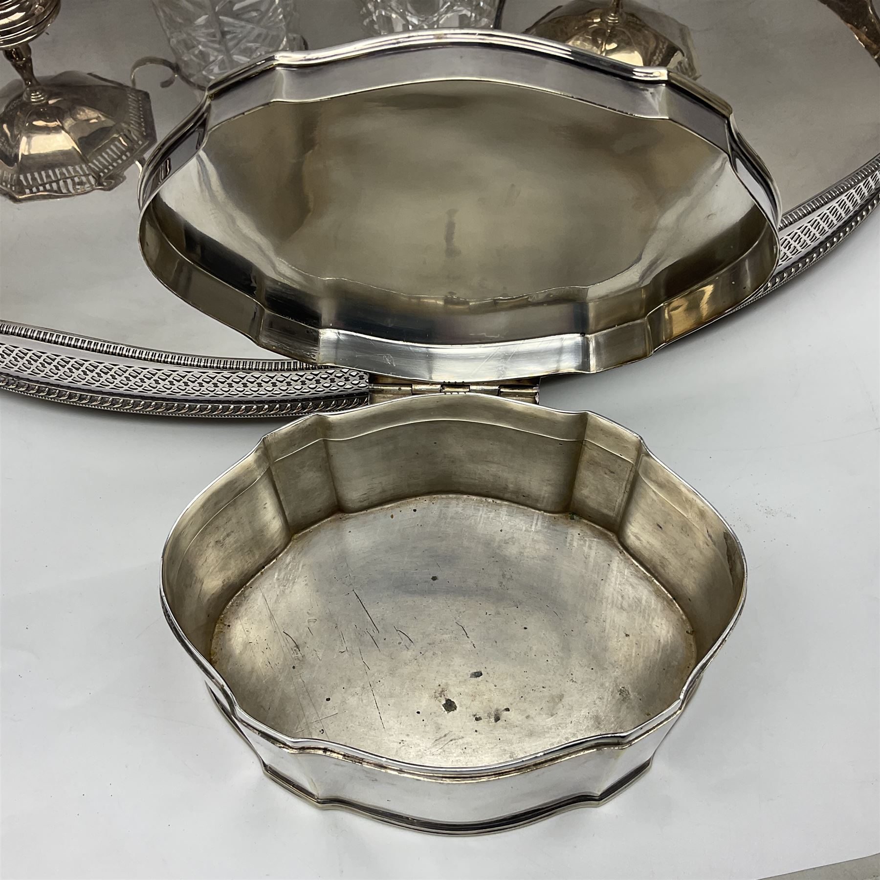 Pair of Mappin and Webb silver plate pierced pedestal bon bon dishes, together with other silver plate comprising teapot stand engraved with lion's head to centre, two cut glass claret jugs, two bottle coasters with acorn decoration, two open salts upon dolphin mounts, tea caddy, three piece cruet set and a large oval tray with pierced sides and upon four ball feet