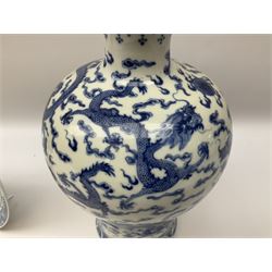 20th century Chinese blue and white vase of inverted baluster form, decorated with dragons chasing a flaming pearl amidst clouds, above a tumultuous sea, raised on a turned wooden stand, together with blue and white charger, decorated with children playing blind mans bluff with a moth and cell boarder H36cm