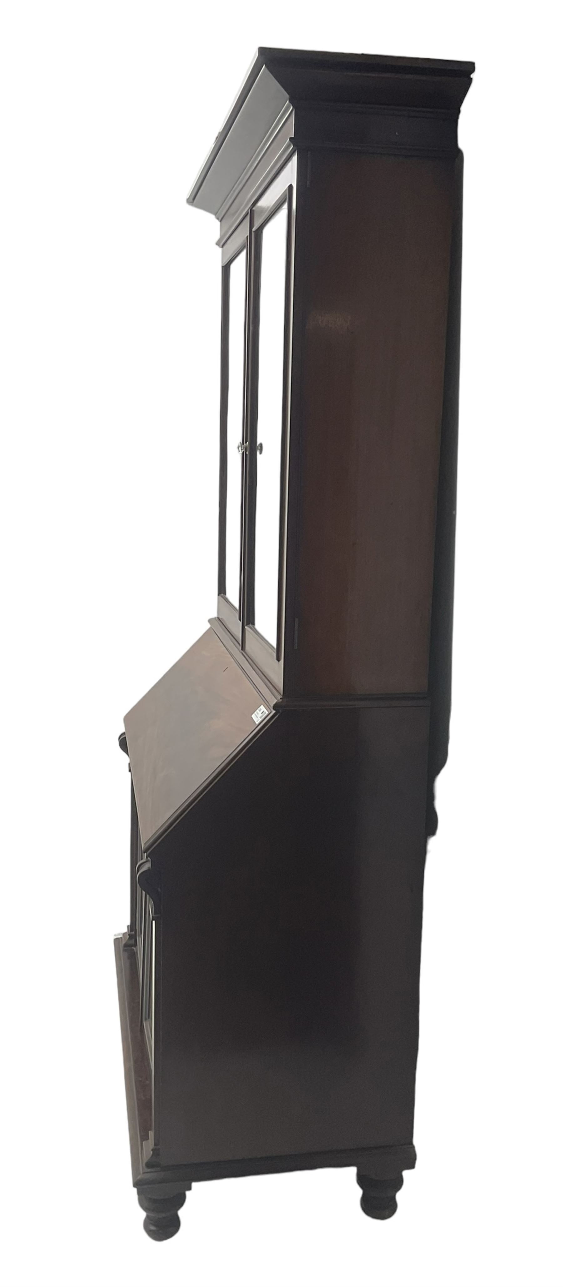 Early 19th century figured mahogany bureau bookcase, projecting splay moulded cornice over three adjustable shelves enclosed by two glazed doors, fall front revealing pigeonholes, cupboard and drawers, pull-out strays with scroll carved terminals, double cupboard with two panelled doors, on turned feet 