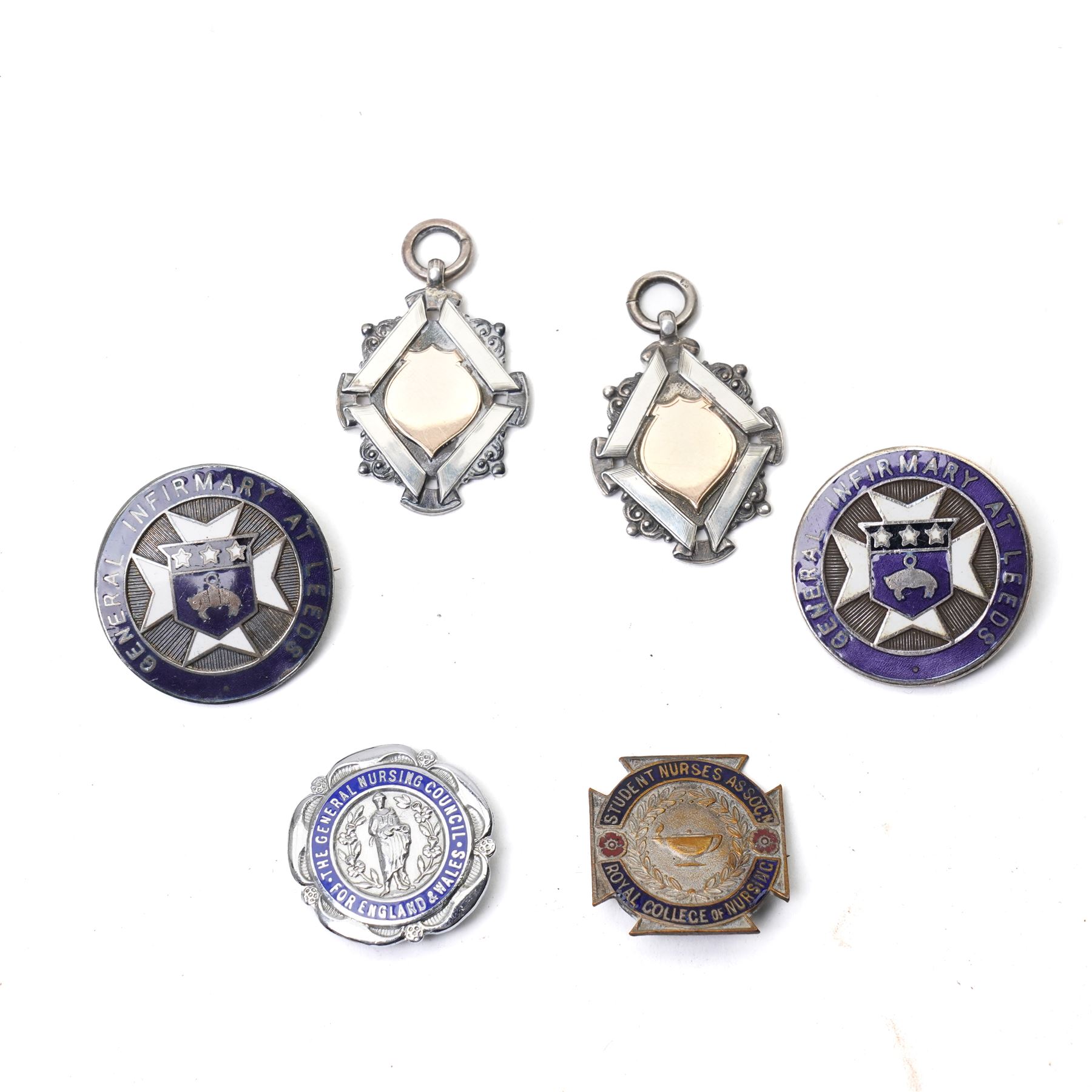 Group of early 20th century sporting medallions, fobs and badges, including two silver Inter Varsity 1/4 mile cased medallions, two silver fobs, white metal and enamel cricket fob etc, one awarded to John Barugh Fisher (1888-1924) born in Amotherby, studied at Leeds University and became doctor in 1911, later Captain John Barugh Fisher R.A.M.C., together with four early 20th century nurses badges, two for General Infirmary Leeds, three inscribed B.P. Simpson, housed in an inlaid work box