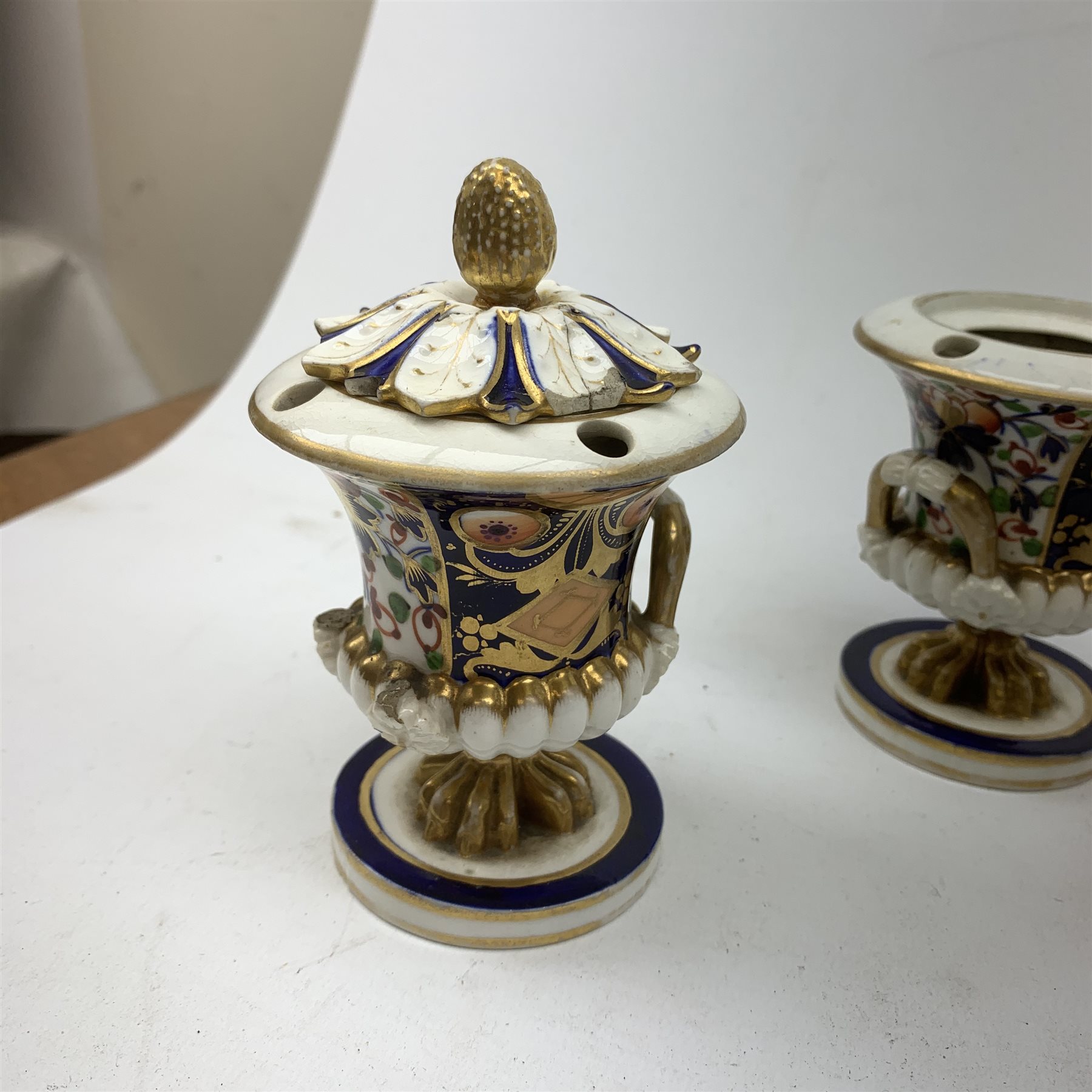 Three Bloor Derby Imari pattern twin handle urms, two examples with covers, each with mark beneath, H12cm, (all a/f), together with a pair of late 19th century Royal Crown Derby Imari pattern urns and covers, each with mark beneath, H13cm, (one significantly a/f). 