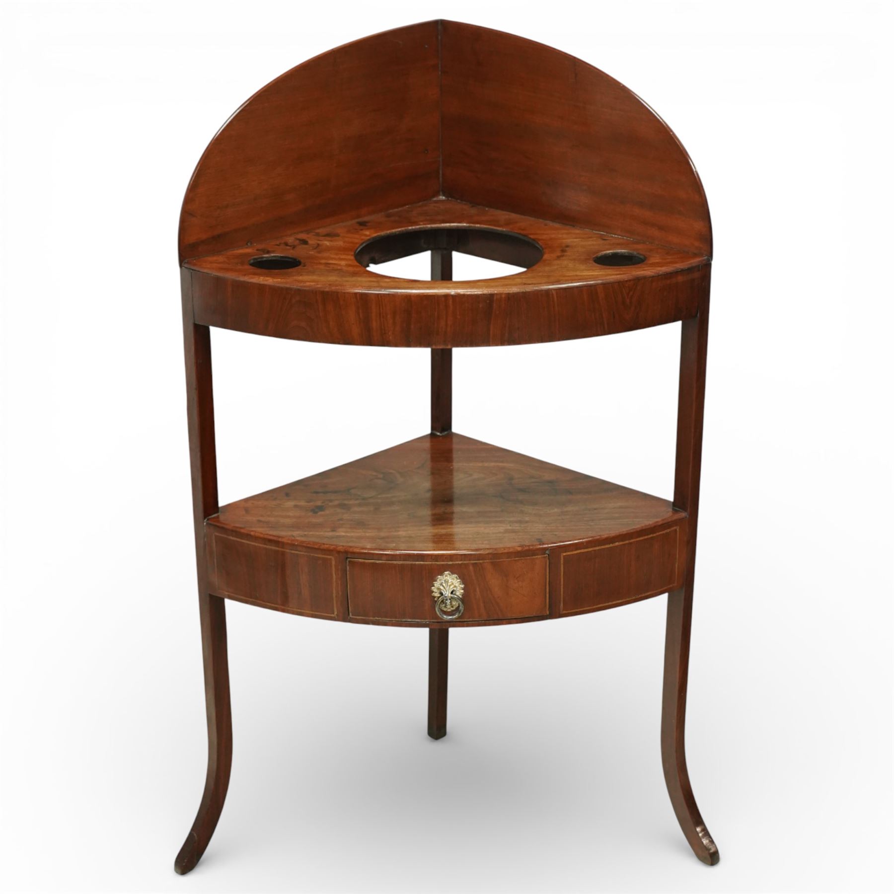 George III mahogany corner washstand, the shaped splash back above a quarter circular top with central basin aperture and flanking soap holes, undertier shelf, single bowed drawer with brass ring handle, raised on slender square and cabriole supports