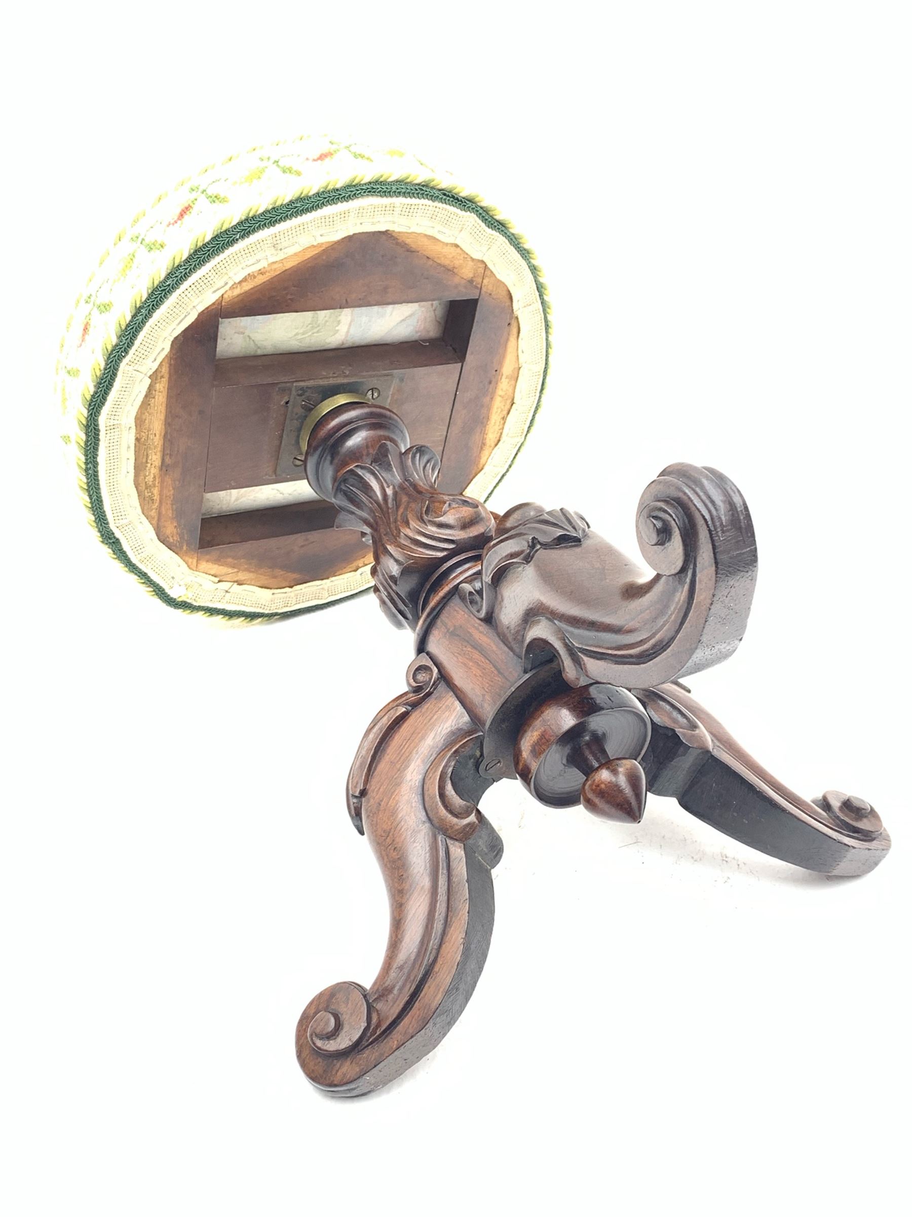Victorian rosewood rise and fall piano stool, the floral needlework upholstered seat raised on floral and scroll carved tripod base