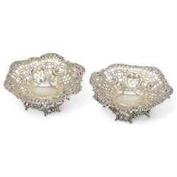 Pair of late Victorian silver bon bon dishes, of hexagonal form with embossed and pierced scrolling decoration, upon a circular pierced base, hallmarked Goldsmiths & Silversmiths Co, Birmingham 1893, W11cm, H4cm