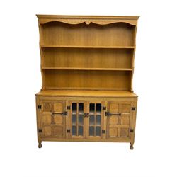 Yorkshire oak - adzed oak dresser, the rack with projecting cornice over shaped frieze and two shelves, the dresser fitted with central glazed double cupboard flanked by two panelled single cupboards, panelled sides