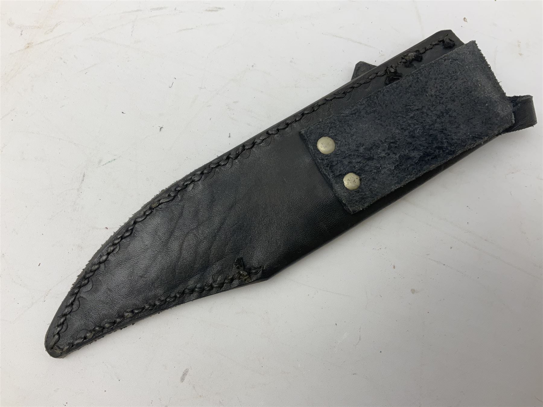Large Bowie knife the 21cm steel blade marked J.E. Middleton & Sons Rockingham Street Sheffield with brass cross-piece and polished horn grip scales; in leather sheath L36cm overall