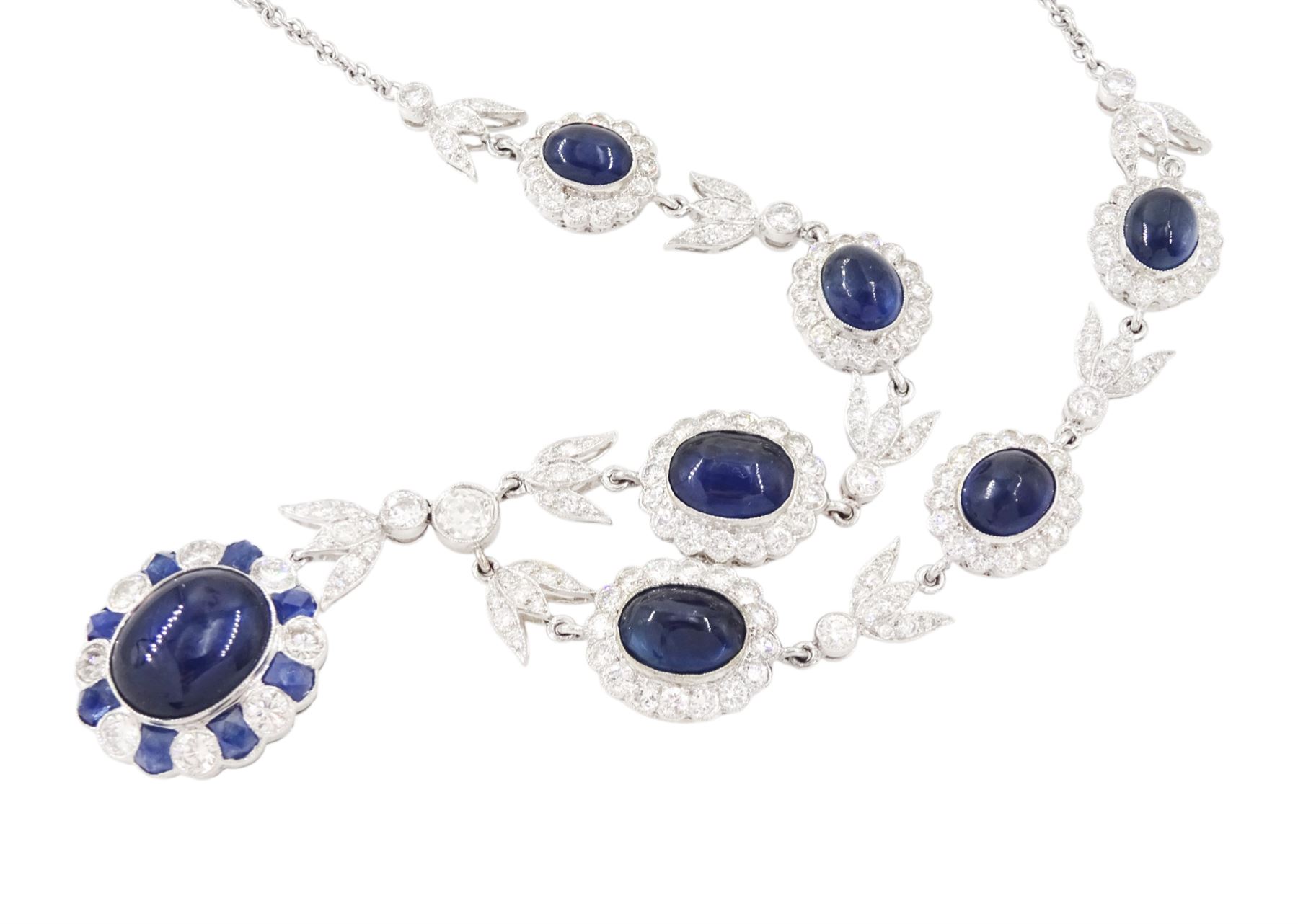 18ct white gold sapphire and diamond milgrain set necklace, oval cabochon cut sapphire surrounded by eight round brilliant cut diamonds and eight French cut sapphires, suspending from a diamond set leaf pendant, single round brilliant cut diamond and a larger old cut diamond, the chain set with six graduating cabochon cut sapphires, each surrounded by diamonds and spaced by a single diamond and a diamond set leaf, to a belcher link chain necklace, hallmarked, total sapphire weight approx 27.00 carat, total diamond weight approx 7.50 carat