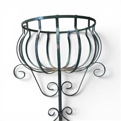 Matched pair of antique metal plant stands, each with circular strapwork basket tops, the scrollwork supports raised on an X-form base, in green painted finish with rustic patina