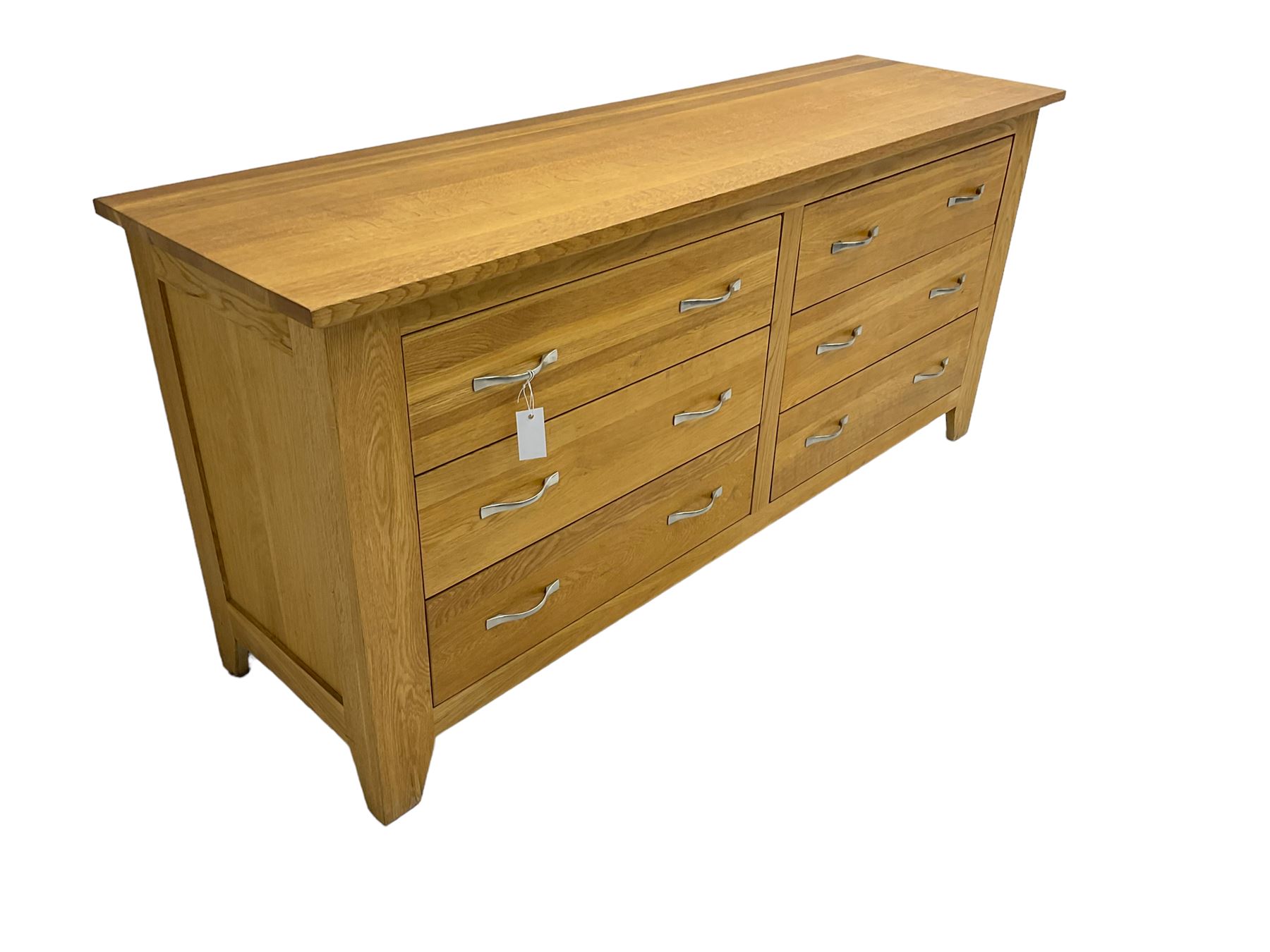 Contemporary wide oak straight-front chest, fitted with a bank of six drawers with chrome handles, on tapered feet