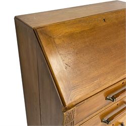 Early to mid-20th century oak bureau, the fall front enclosing fitted interior, three long drawers, on turned and carved baluster supports united by sledge platform 