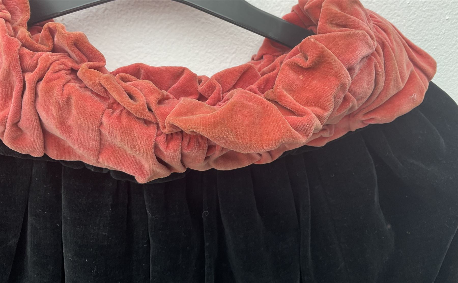 Full length 1930's childs black velvet cape, with ruched collar and red velvet lining, with a single button neck fastening 