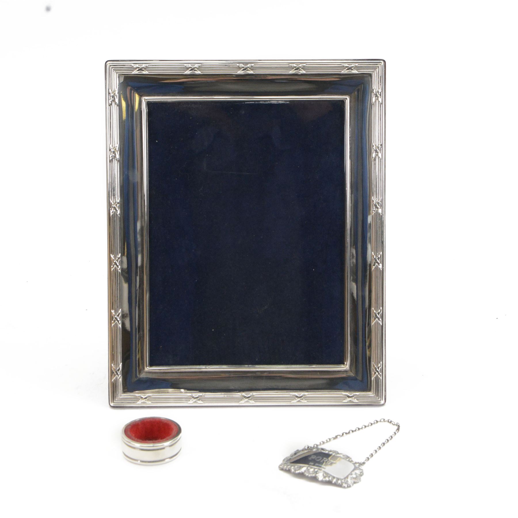 Modern silver mounted photograph frame, of rectangular form with reed and ribbon border, hallmarked Carr's of Sheffield Ltd, Sheffield 2000, together with a silver napkin ring and a silver Port decanter label, both hallmarked, frame H26cm x 21cm