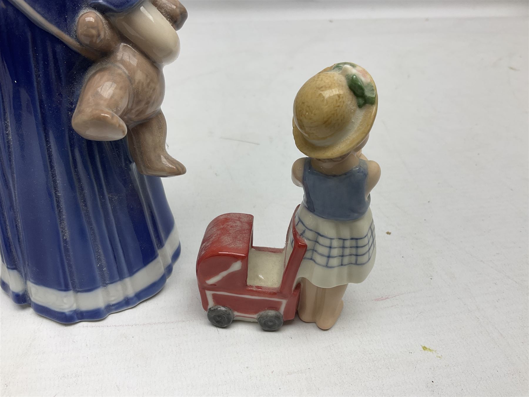 Four Royal Copenhagen figures, comprising Else with teddy no. 671, Snowman no. 158, Elsa no. 404, an mini collection girl with pram no.014, all with mark beneath  
