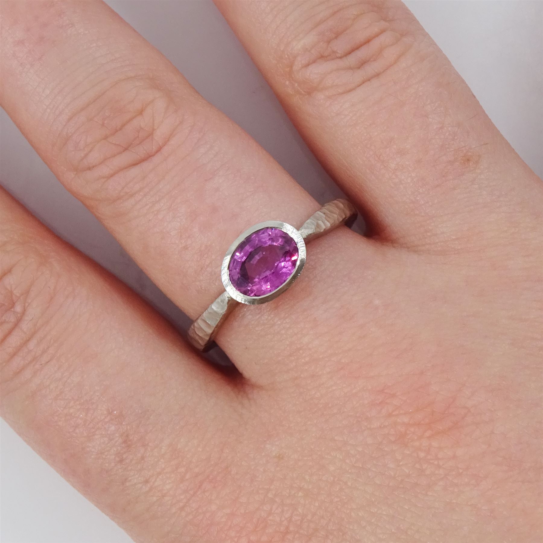 Platinum pink sapphire ring, single bezel set sapphire of approx 1.40 carat, to a planished shank, London 2019