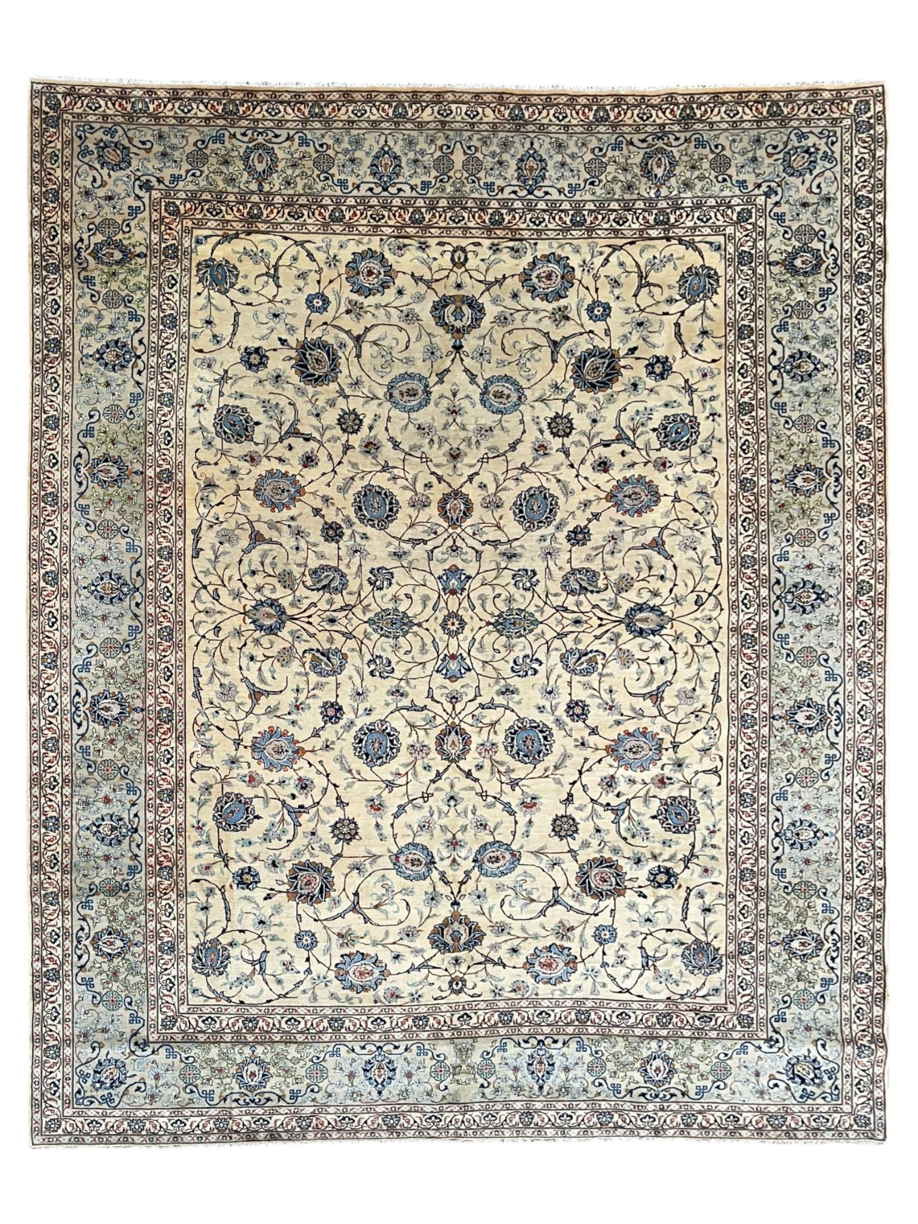 Persian Kashan ivory ground carpet, the field decorated with swirling foliate patterns and stylised plant motifs, scrolling border decorated with palmettes, within floral pattern guard stripes 